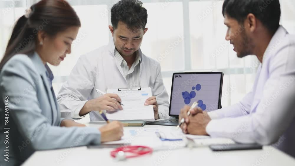 Shared medical knowledge benefits his coworkers and patients. Team of doctors is talking and discussing in a conference room at the hospital. Shared medical knowledge benefits his coworkers and patients. Team of doctors is talking and discussing in a conference room at the hospital.