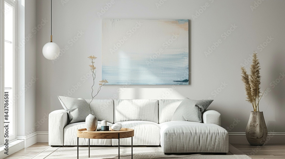 Naklejka premium Clean design and confortable living room with a sofa against a wall with an abstract art of work in light pastel colors