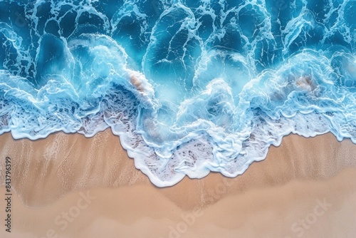 Aerial top down view of ocean waves crashing on the beach, perfect for a summer vacation background