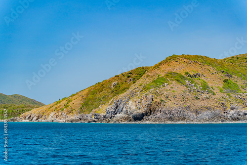 A steep bank. The rocky shore of the island in the sea. 