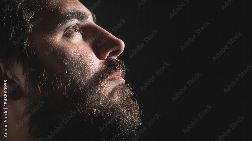 Obraz premium pensive bearded mans profile aged 3035 dramatic black background contemplative portrait