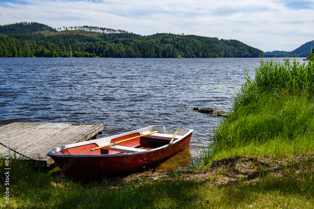 Small red boat on lake. Summer in Sweden Small red boat on lake. Summer in Sweden