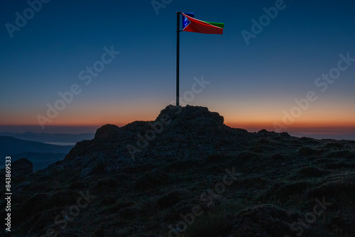 flag waving on top of mountains