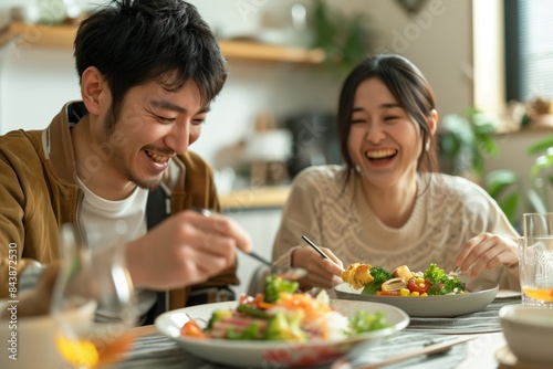 A japanese couple happily enjoying a meal together at home, white clean modern living room