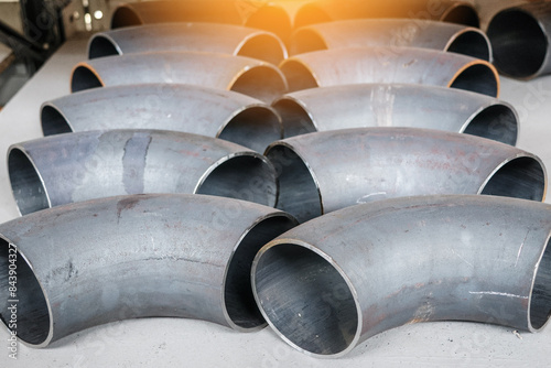 A bunch of pipes are stacked on top of each other. The pipes are all the same size and shape, and they are all made of metal. The image gives off a sense of order and uniformity photo