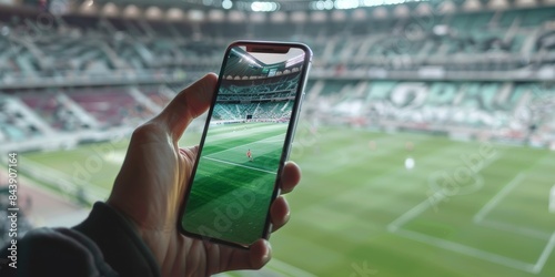 Close up of a hand holding an iPhone with white display on it, inside a soccer stadium in France.