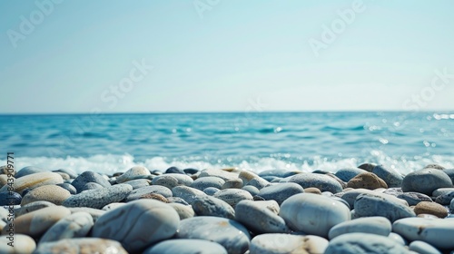 Beach made of stones with a backdrop of a clear sky and ocean