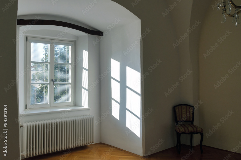Empty interior of a old house with reflections of sunlight through the window with blinds Empty interior of a old house with reflections of sunlight through the window with blinds