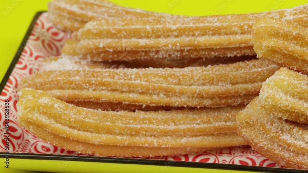 plusieurs churros, en gros plan, sur un fond jaune