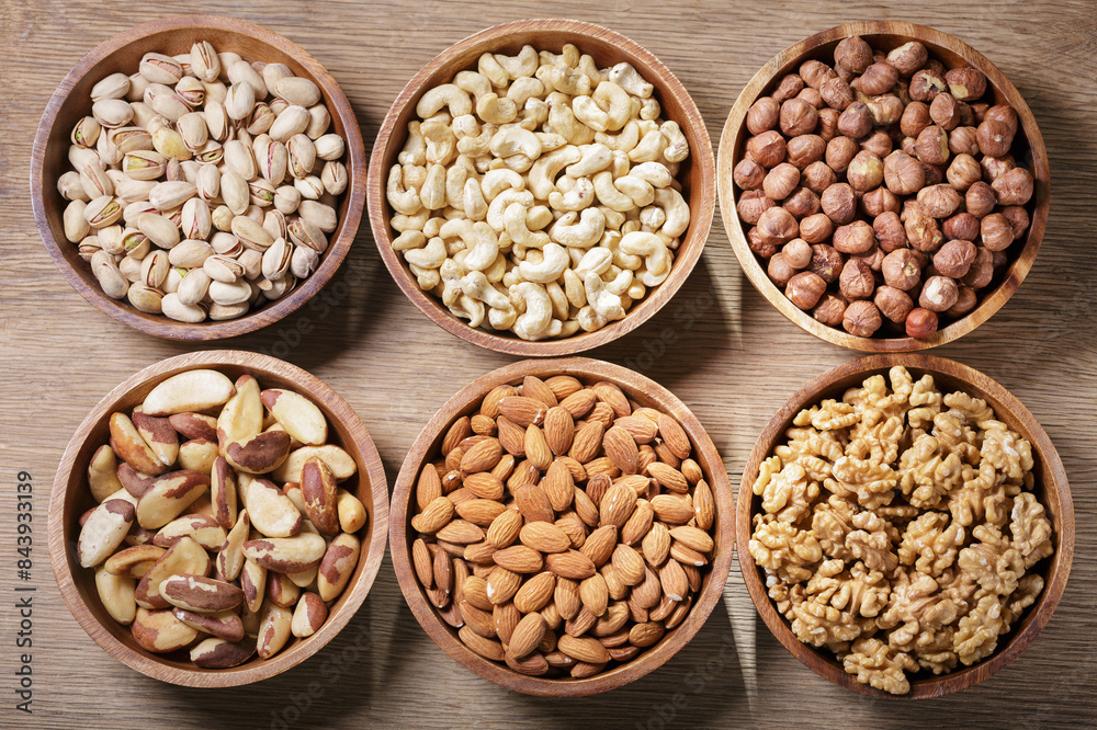 Bowls of various mixed nuts on wooden table Bowls of various mixed nuts on wooden table