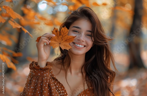 Young Woman Holding Autumn Leaf in Forest