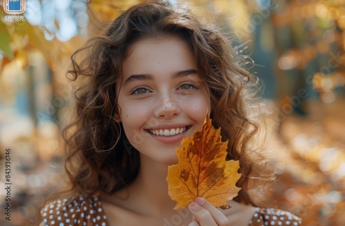 Young Woman Holding Autumn Leaf in Forest