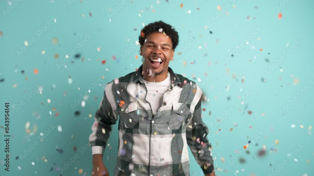 Cheerful man celebrating big win showered in confetti Cheerful man celebrating big win showered in confetti