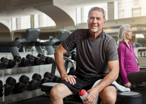 Fitness, gym and portrait of old man relax with water bottle for training, exercise and workout. Sports, retirement and person listening to music, audio and podcast for wellness, health and resting