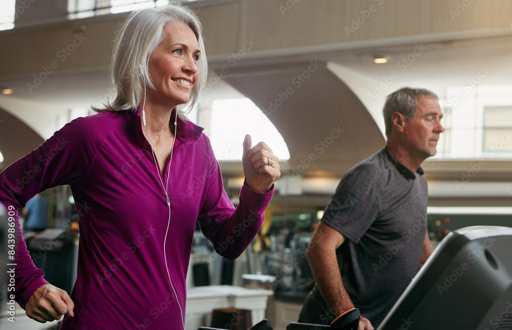 Obraz premium Fitness, running and mature woman on treadmill in gym for health, wellness and body exercise. Smile, active and people on cardio equipment for endurance workout in training center for marathon.