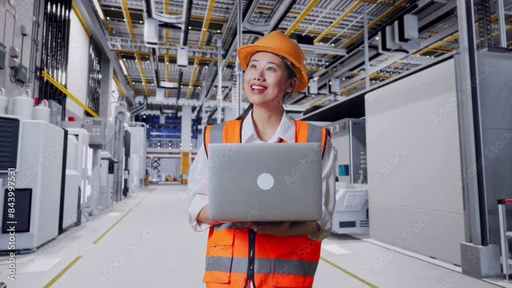 Asian Female Engineer With Safety Helmet Working On A Laptop And Looking Around While Standing At Factory Digitalization Asian Female Engineer With Safety Helmet Working On A Laptop And Looking Around While Standing At Factory Digitalization
