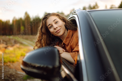 Happy woman in car window. Hair in wind. Girl travels by car.  Lifestyle, travel, tourism, nature, active life © maxbelchenko
