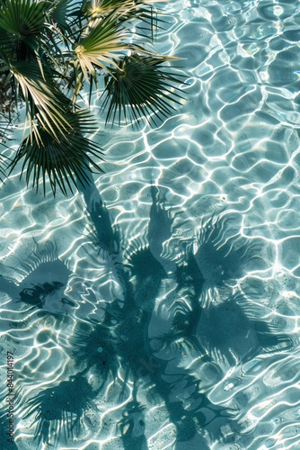 Palm tree shadows on blue water background, palm branch on beach pattern, ocean wave sunlight palm shadow © NendeR