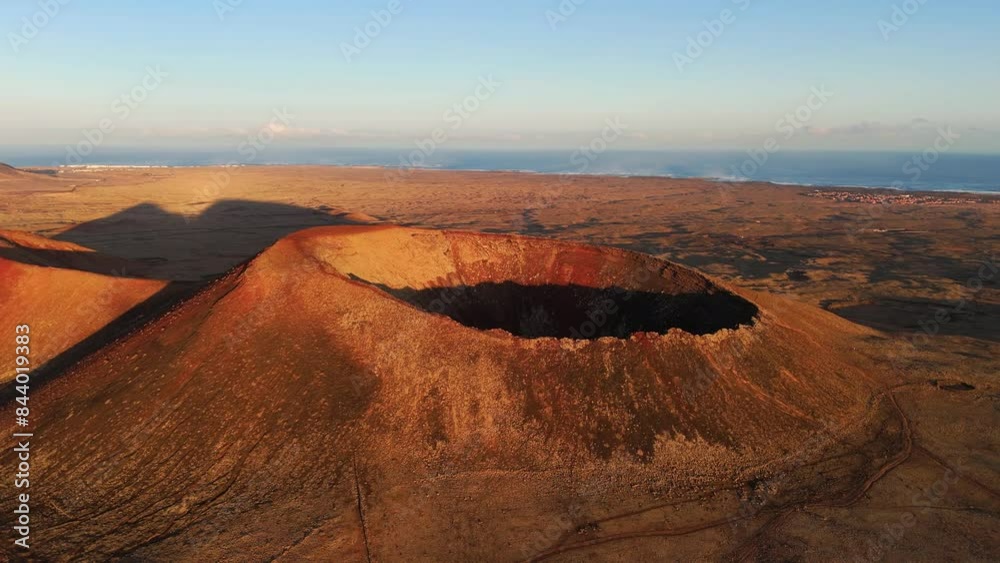 Aerial clip of the dramatic Volcan Calderon Hondo volcano with deep crater Corralejo and Lajares Fuerteventura Canary Islands Spain