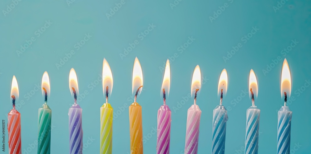 Colorful birthday candles on a blue background with copy space for a banner design. Colorful birthday candles on a blue background with copy space for a banner design.