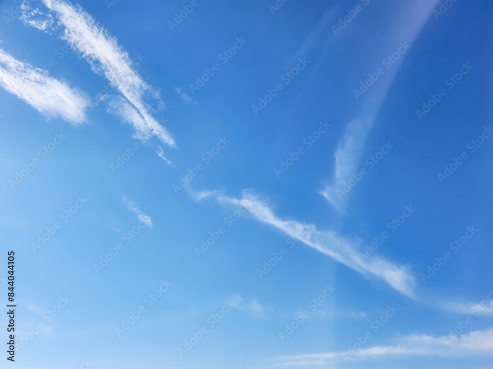 A tranquil display of wispy clouds dancing against the backdrop of a clear, expansive blue sky. A tranquil display of wispy clouds dancing against the backdrop of a clear, expansive blue sky.