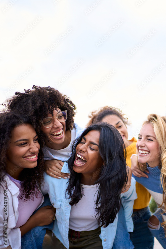 Vertical. Group of young different races only women friends standing having fun piggyback outdoor. Multiracial female laughing enjoying leisure time together. Generation z happy girls community people Vertical. Group of young different races only women friends standing having fun piggyback outdoor. Multiracial female laughing enjoying leisure time together. Generation z happy girls community people