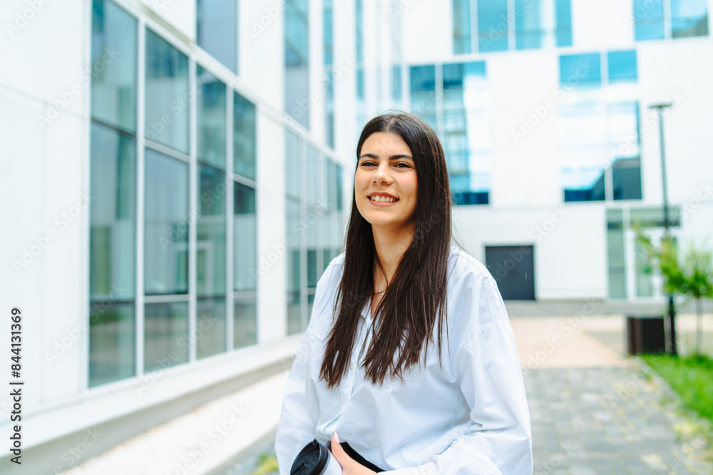 One young successful business woman going to work at business office modern building while holding coffee and papers One young successful business woman going to work at business office modern building while holding coffee and papers