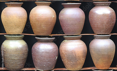 Rows of old jars lined up to form a wall. photo