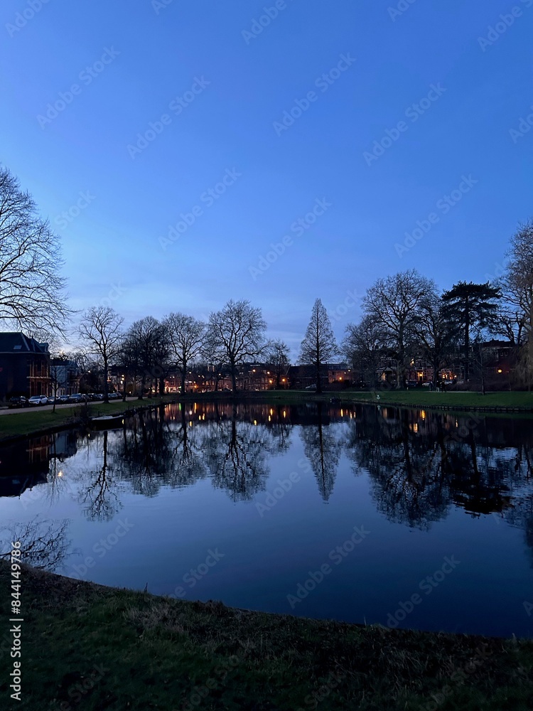 Obraz premium Scenic view of river and buildings on shore in evening