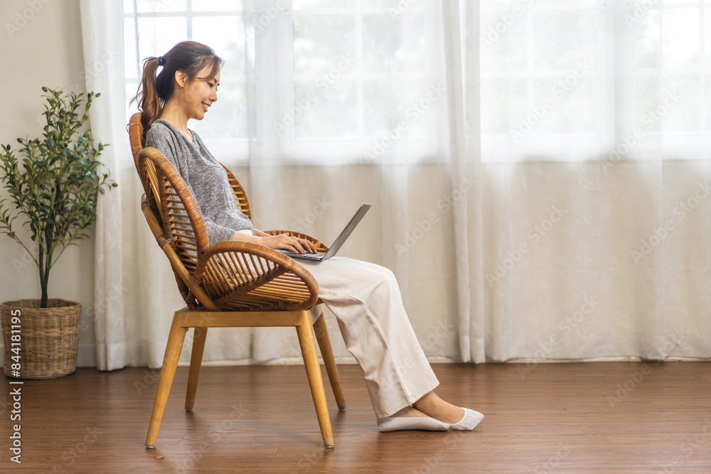 Young smiling asian woman relax using laptop conference work,learning education,study online,webinar podcast,creative woman looking at screen, shopping, online marketing at home