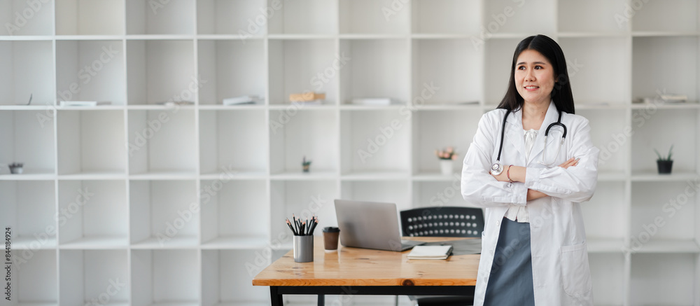Confident female doctor in white lab coat with stethoscope, standing in modern office with laptop and bookshelves. Confident female doctor in white lab coat with stethoscope, standing in modern office with laptop and bookshelves.