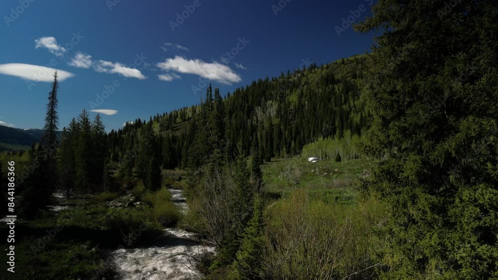 Aerial ascending over RV camped along Logan River in northern Utah mountains and forest in springtime Aerial ascending over RV camped along Logan River in northern Utah mountains and forest in springtime