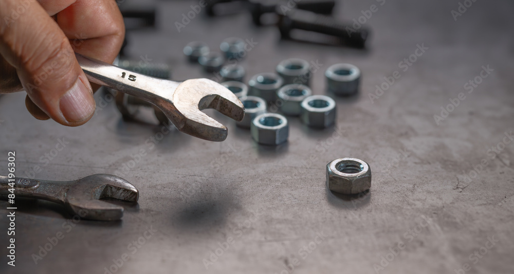 Fototapeta premium Mechanic hand holding socket wrench on steel work bench