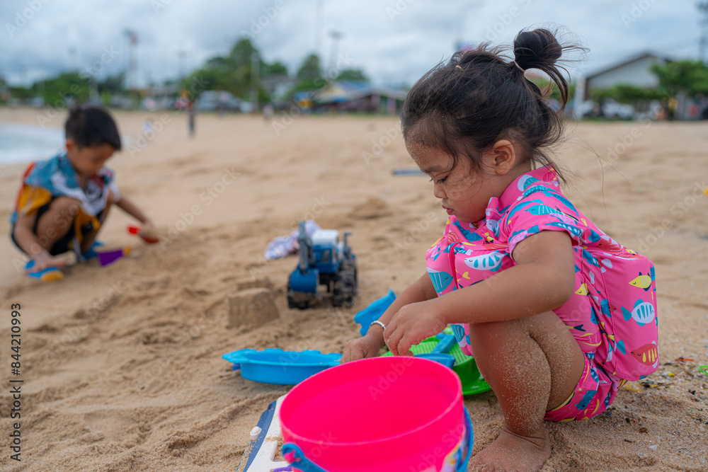Happy asian kids boy and girl enjoying play toy on exotic sea beach Happy asian kids boy and girl enjoying play toy on exotic sea beach