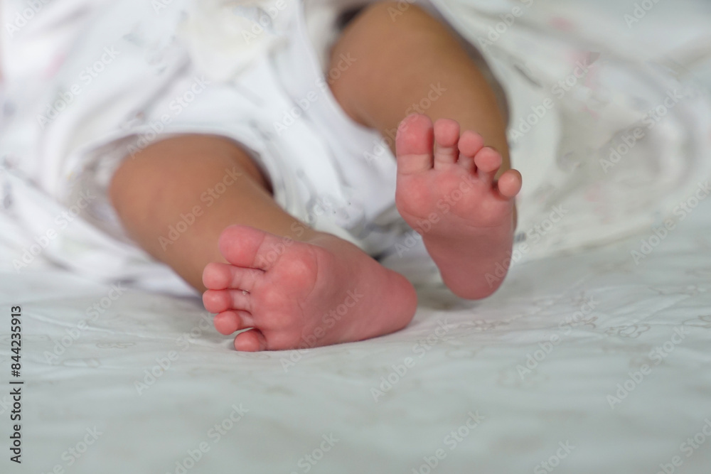 Baby's soles on a white background of baby sheets. Concept of infancy, innocence, mother and baby, newborn, gentle, beginning. Baby's soles on a white background of baby sheets. Concept of infancy, innocence, mother and baby, newborn, gentle, beginning.