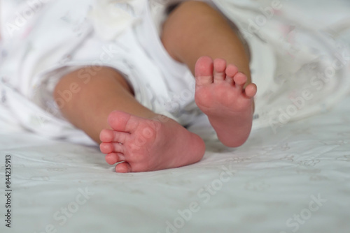 Baby's soles on a white background of baby sheets. Concept of infancy, innocence, mother and baby, newborn, gentle, beginning. © Aoy_Charin