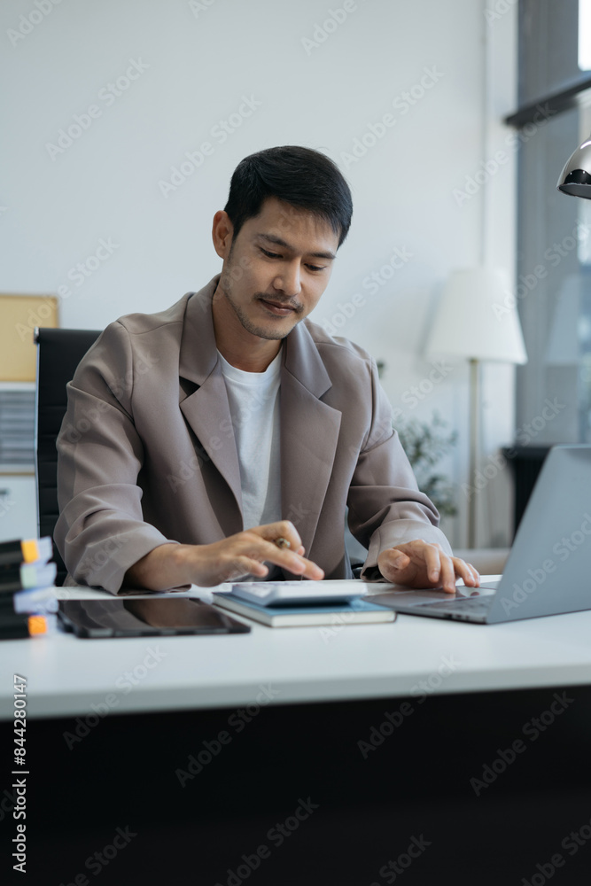 Fototapeta premium Successful businessman sitting in the office Happy man, entrepreneur, small business owner, working online.