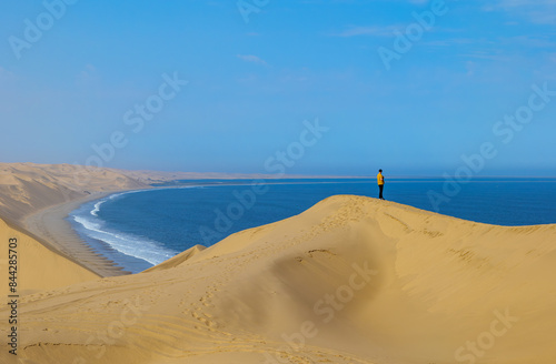 Sandwich harbour dunes, morning, sunrise landscape.. Walvis Bay Namibia Africa. Man standing on dune