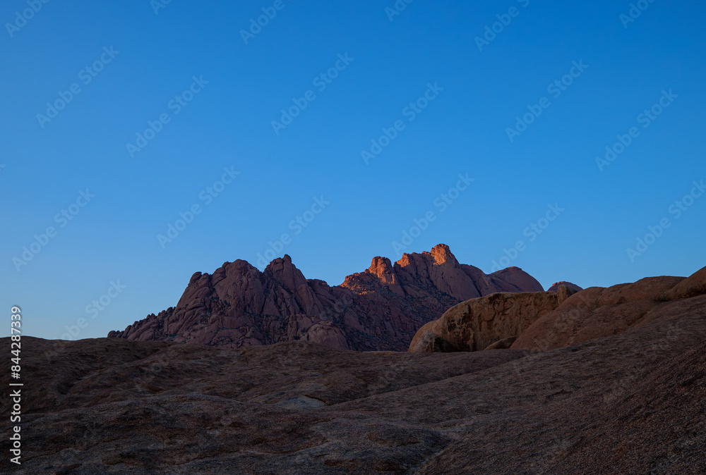 The Spitzkoppe is a group of bald granite peaks or inselbergs located between Usakos and Swakopmund in Namib desert I Namibia, sunset photo The Spitzkoppe is a group of bald granite peaks or inselbergs located between Usakos and Swakopmund in Namib desert I Namibia, sunset photo