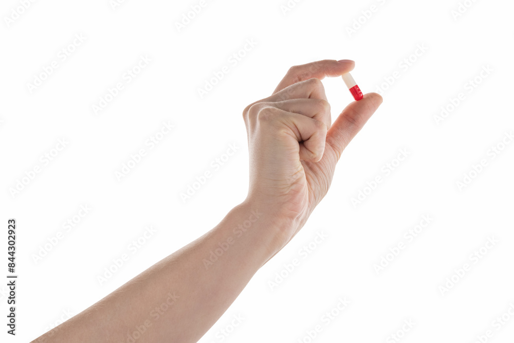 Female hand hold red and white pill isolated on white Female hand hold red and white pill isolated on white