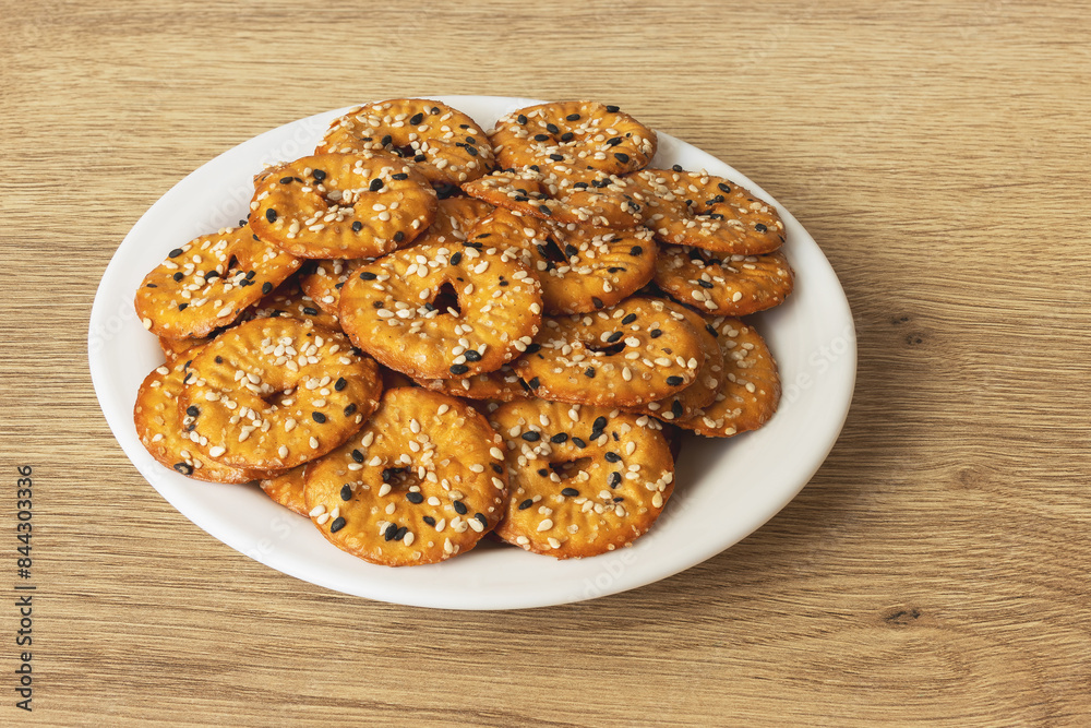 Salted round pretzels with black and white sesame on a plate Salted round pretzels with black and white sesame on a plate