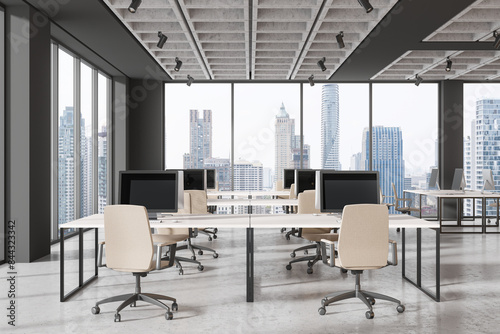 Office coworking interior with pc monitors on tables in row  panoramic window