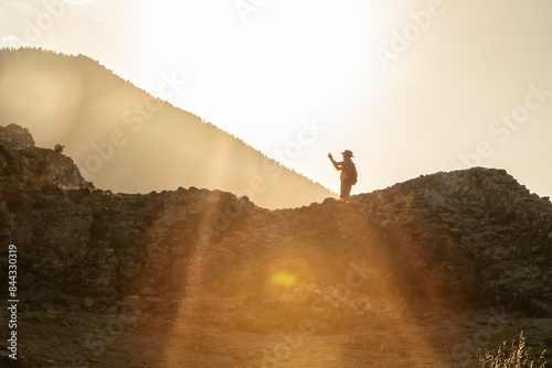 Archeologist exploring ancient ruins on top of mountain at sunset