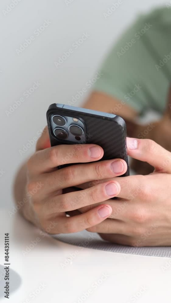 A smartphone in a man's hands close-up in the foreground, a brown dog sits on its owner's lap in the background. Joint leisure with a pet. A companion dog. A smartphone in a man's hands close-up in the foreground, a brown dog sits on its owner's lap in the background. Joint leisure with a pet. A companion dog.