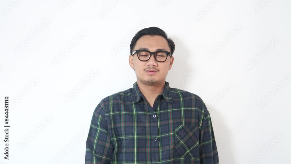 A man from Asia wearing a green shirt, looking surprised, and then gesturing to stop someone from continuing an action. Isolated on a white background. A man from Asia wearing a green shirt, looking surprised, and then gesturing to stop someone from continuing an action. Isolated on a white background.