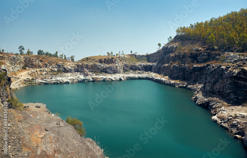 baghmundi purulia, west bengal tourism, marble lake water project, geographical landscape, igneous rock formation, rustic terrain, serene nature, deep blue green water, stone boulders, crater created 