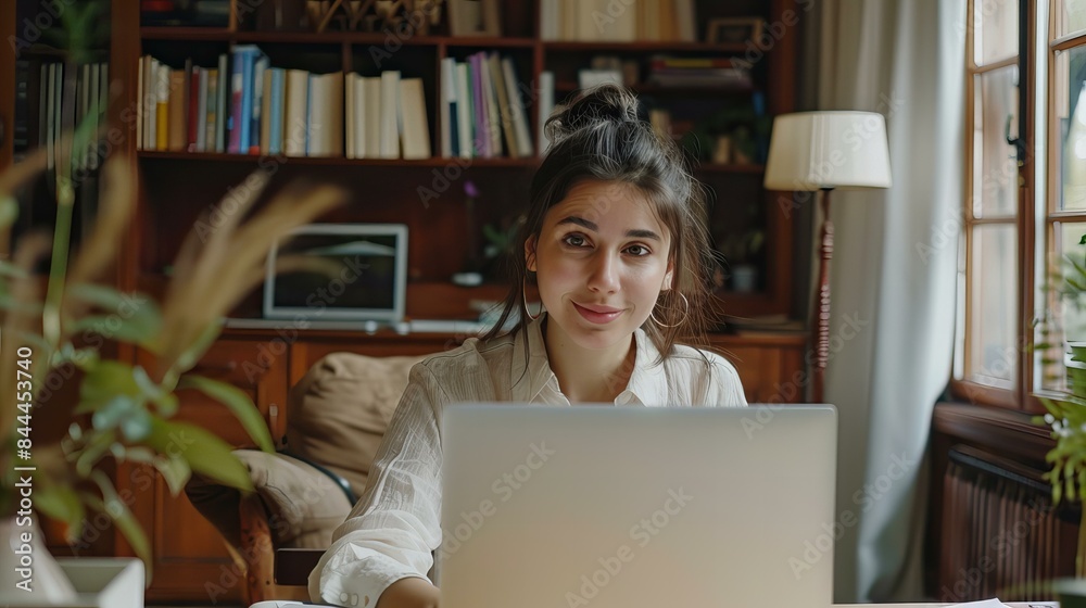 A cheerful woman in casual attire works on her laptop, smiling at the camera. She exudes confidence and professionalism A cheerful woman in casual attire works on her laptop, smiling at the camera. She exudes confidence and professionalism
