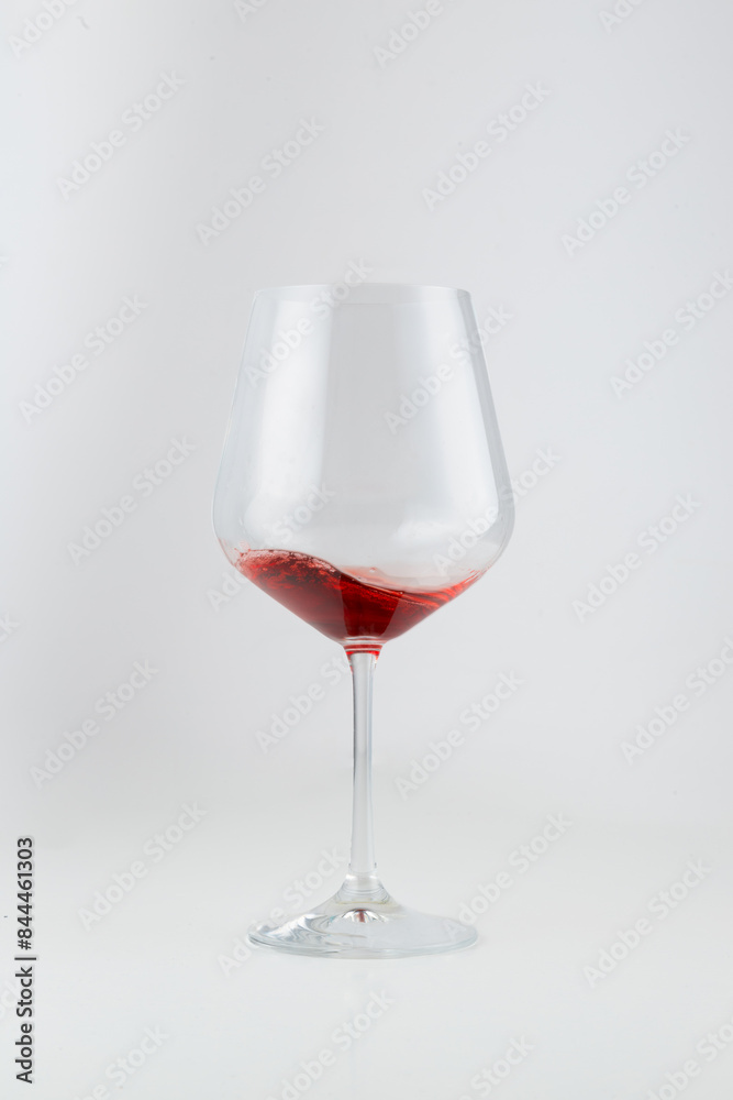 Half-full wine glass with red wine, set against a white background. The elegant swirl of wine highlights its rich color, making it perfect for themes related to wine, beverages, and fine dining. Half-full wine glass with red wine, set against a white background. The elegant swirl of wine highlights its rich color, making it perfect for themes related to wine, beverages, and fine dining.