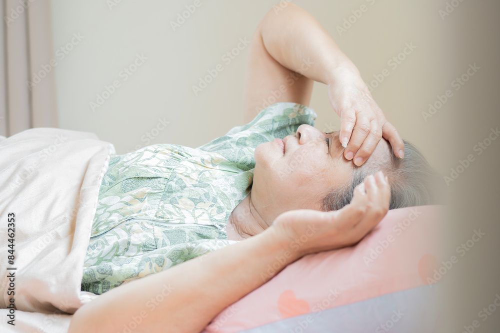 Side view image of depressed elderly Asian female looking upset thinking about life Side view image of depressed elderly Asian female looking upset thinking about life