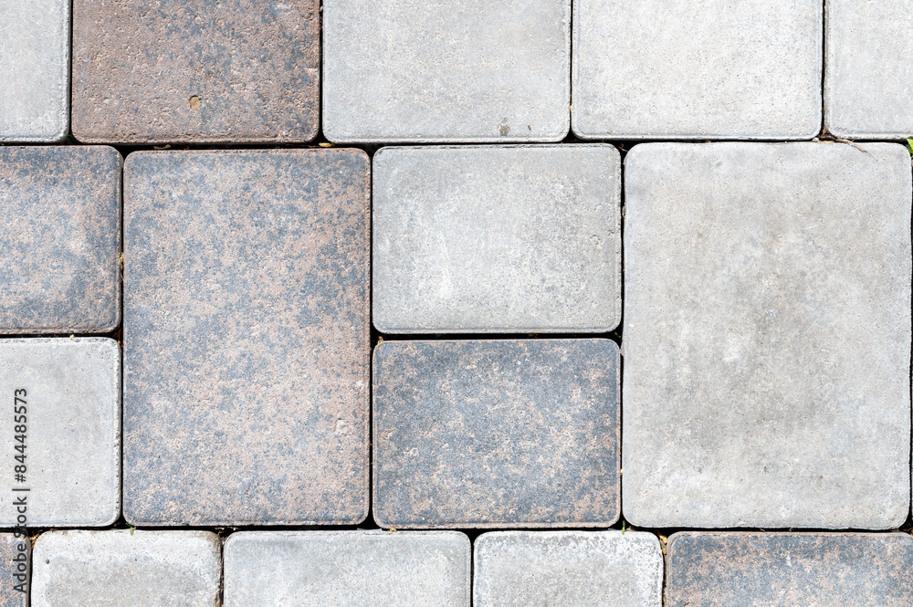 Fototapeta premium Grey and brown cobblestone pavement forming a textured background
